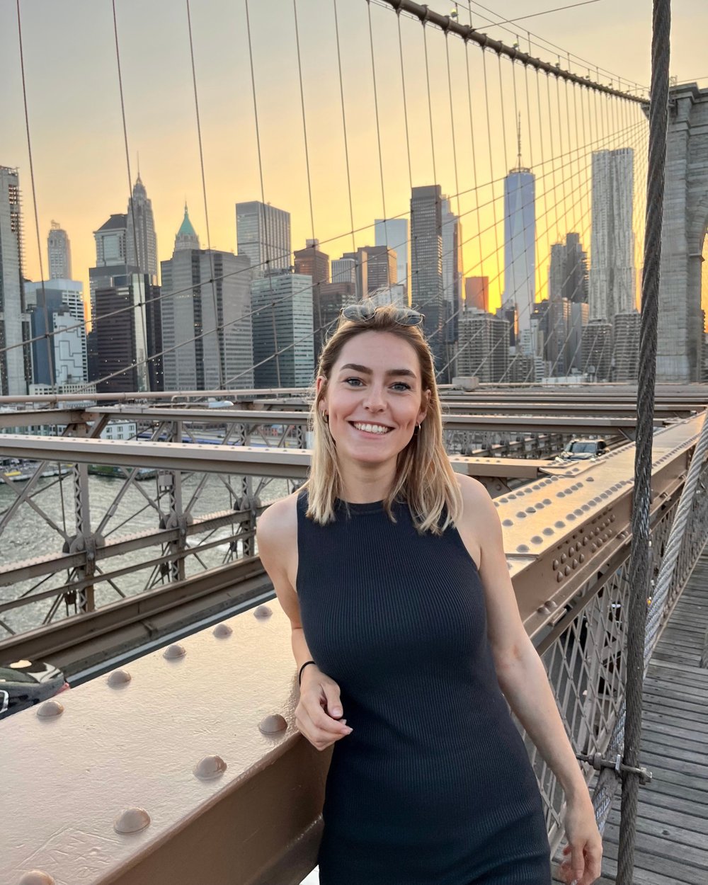 Jennifer Pfeifer lacht auf der Brooklyn Bridge, im Hintergrund die Skyline von New York