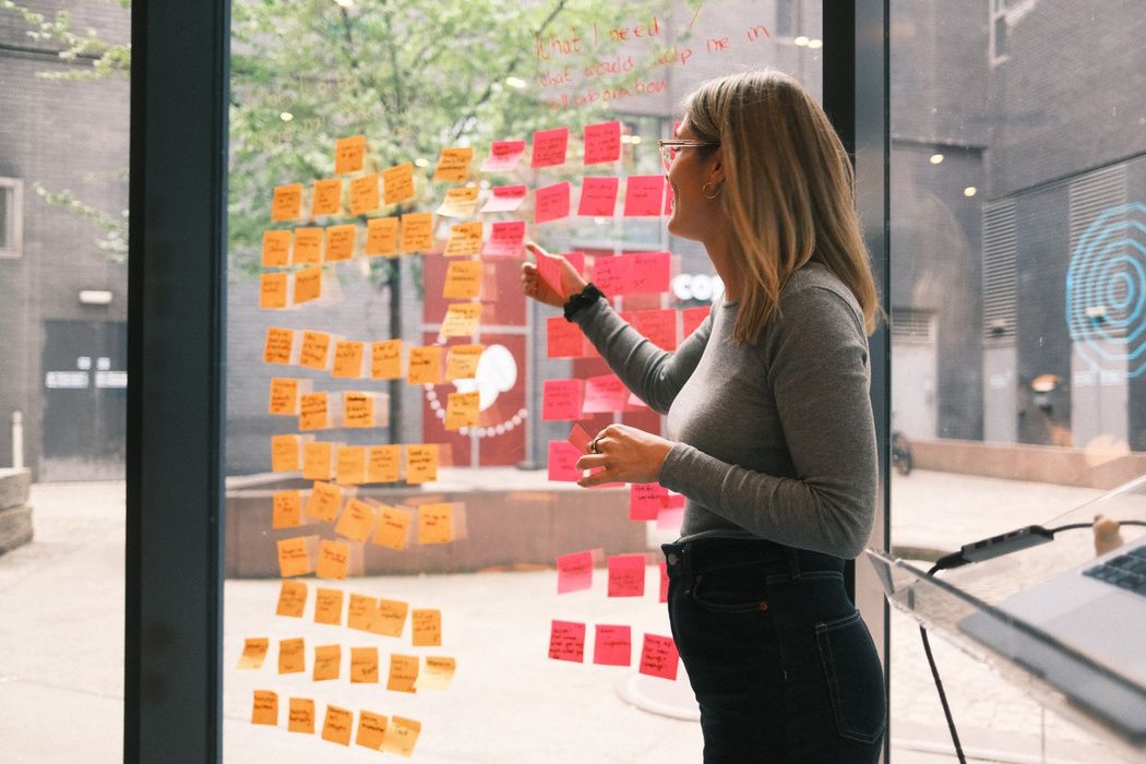 Jennifer Pfeifer moderiert einen Workshop an einer Wand voller Post-its